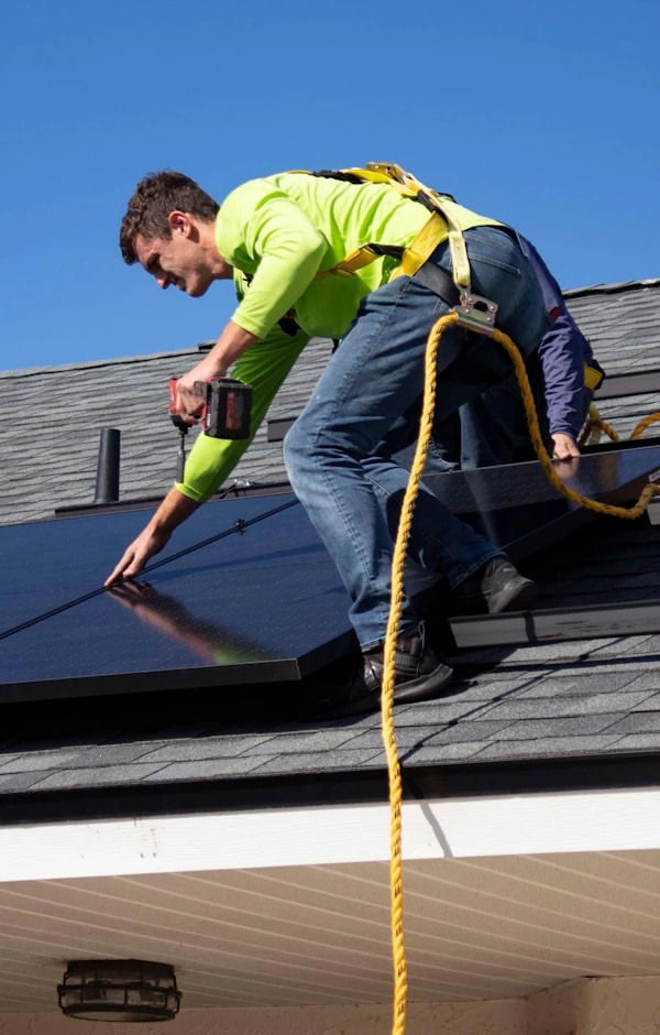 Instalador montando placas solares en un tejado Instalador montando placas solares en un tejado